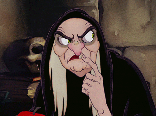 Snow Whites evil queen dressed as old hag looking around questioningly