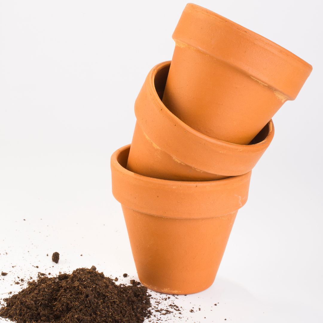 A towering shot of pots next to a pile of dirt