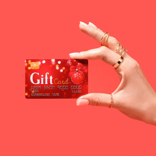 a hand holding a red gift card over a red background